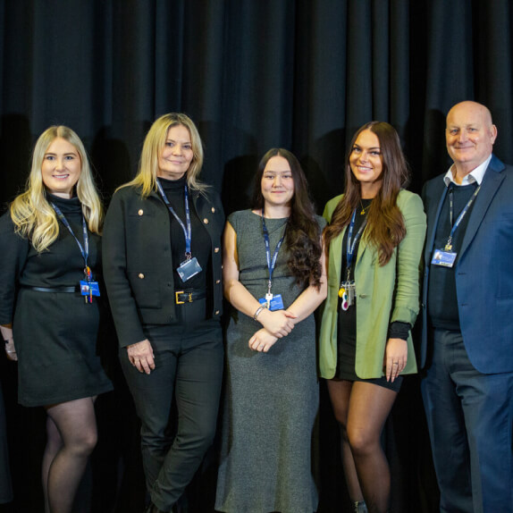 Our dedicated Business Development Team standing together infront of a Loughborough College popup banner for a group photo
